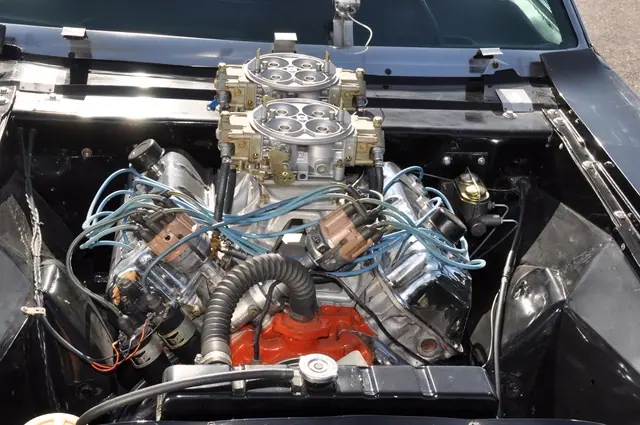 Overhead view of the engine with twin carburetors and blue ignition wires